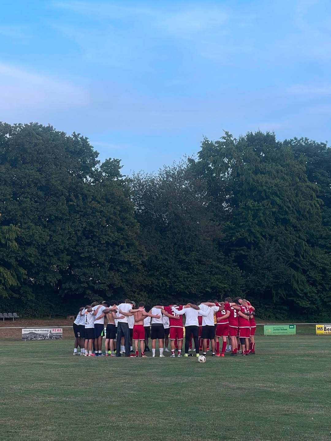Mannschaft im gemeinsamen Kreis auf dem Spielfeld
