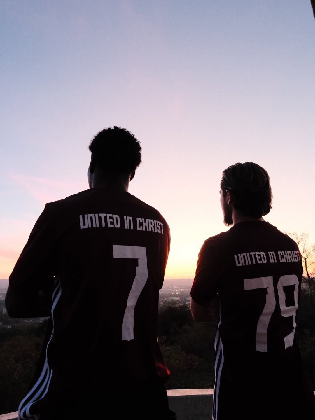 Zwei Spieler zeigen die Rückseite ihrer United-in-Christ-Trikots